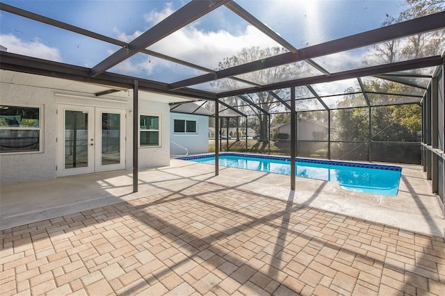 view of pool with french doors, a lanai, and a patio area