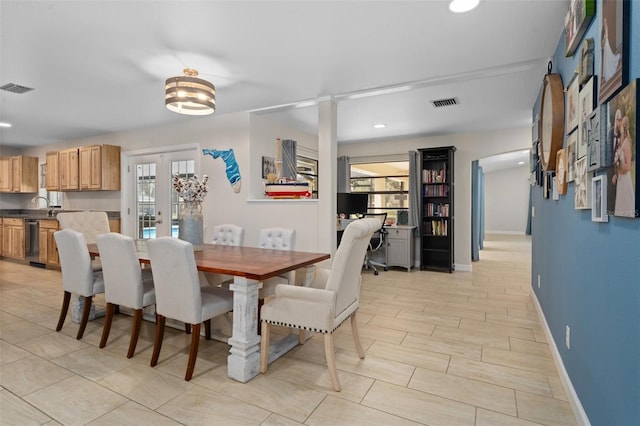 dining area with sink, plenty of natural light, and french doors