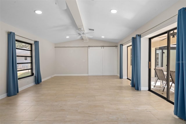 empty room featuring lofted ceiling with beams, a barn door, and ceiling fan