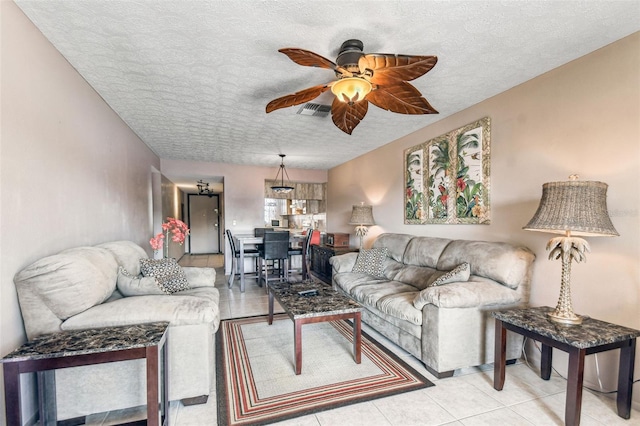 living room with ceiling fan and a textured ceiling