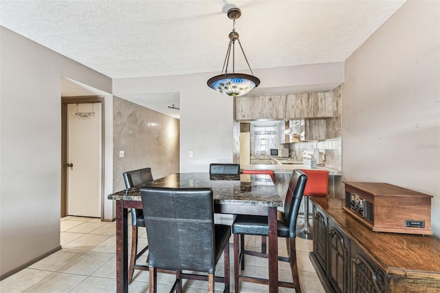 tiled dining space with a textured ceiling