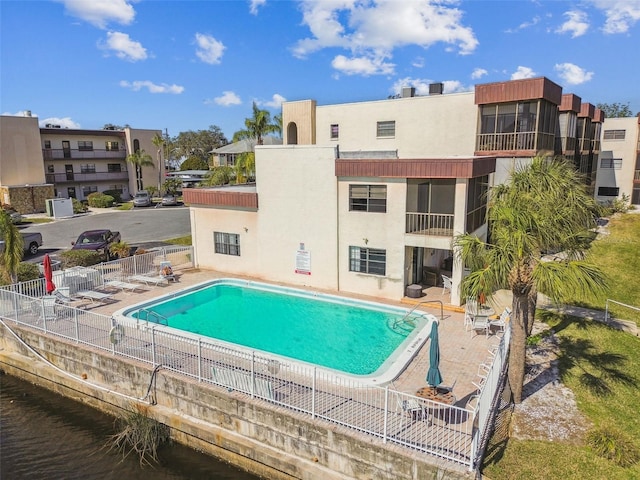 view of swimming pool featuring a water view and a patio area