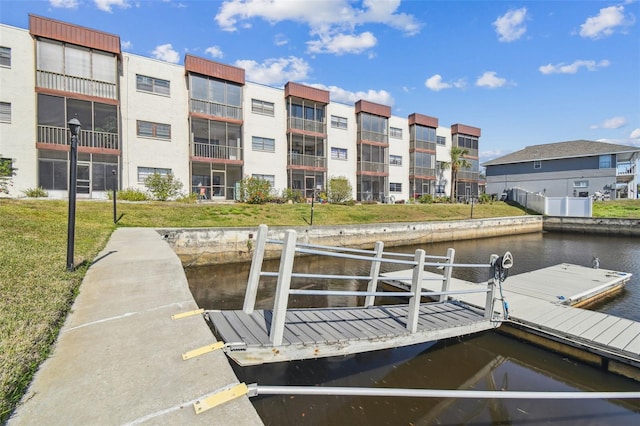 dock area featuring a water view and a lawn