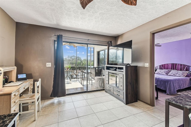 interior space featuring light tile patterned flooring, access to exterior, and a textured ceiling