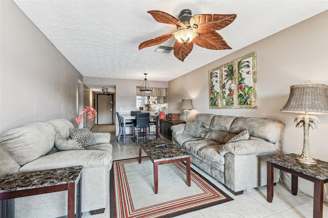 living room featuring ceiling fan and a textured ceiling