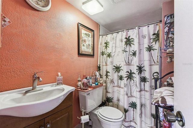 bathroom with vanity, curtained shower, and toilet