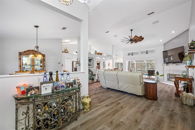 living room with hardwood / wood-style flooring, vaulted ceiling, a premium fireplace, and ceiling fan