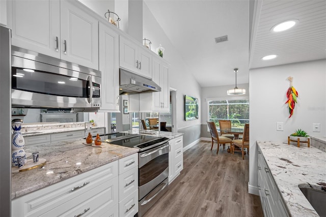 kitchen featuring lofted ceiling, stainless steel appliances, light hardwood / wood-style floors, white cabinets, and decorative light fixtures