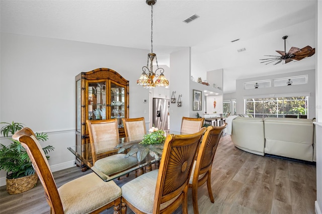 dining room with vaulted ceiling and light hardwood / wood-style flooring