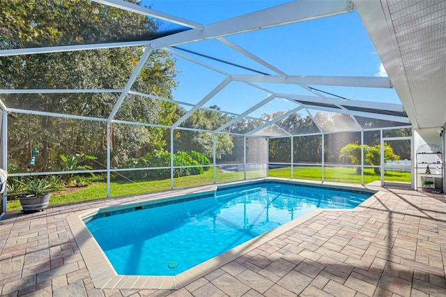 view of pool with a patio, a yard, and glass enclosure