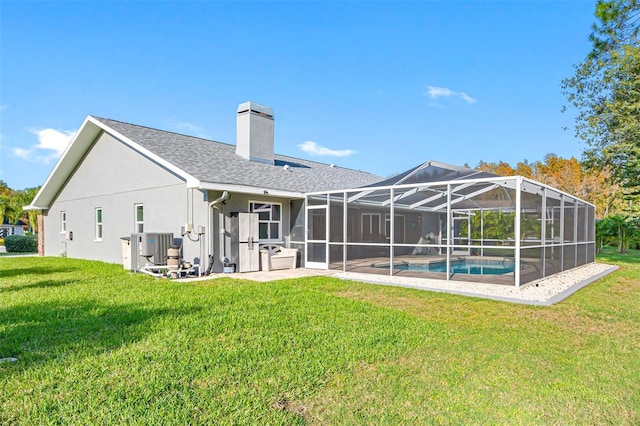 back of property with a patio, a lanai, a lawn, and central air condition unit