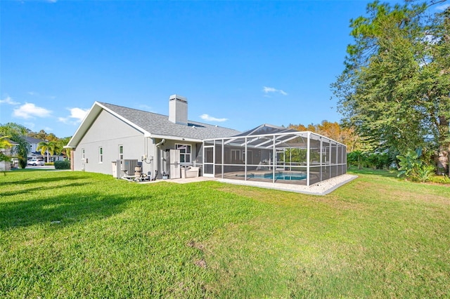 back of house featuring a yard, a lanai, and central AC