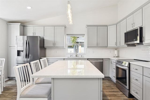 kitchen with a kitchen island, pendant lighting, sink, gray cabinetry, and stainless steel appliances