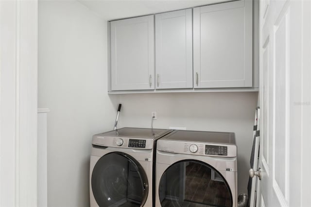 clothes washing area with cabinets and independent washer and dryer