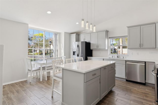 kitchen with gray cabinetry, tasteful backsplash, stainless steel appliances, and a kitchen island