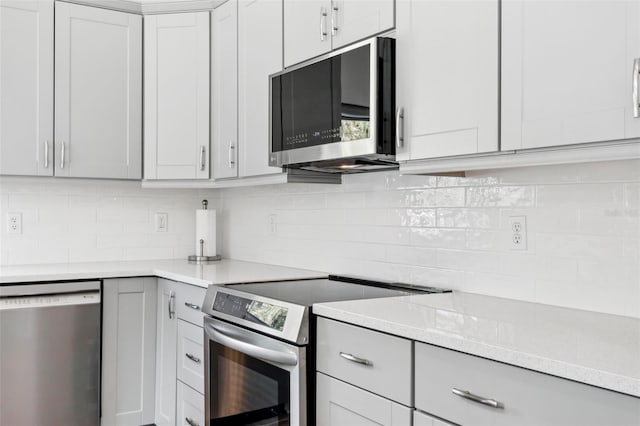 kitchen with stainless steel appliances, light stone counters, and decorative backsplash