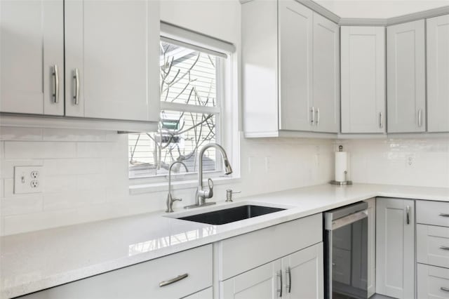 kitchen with sink, gray cabinets, dishwasher, light stone countertops, and decorative backsplash