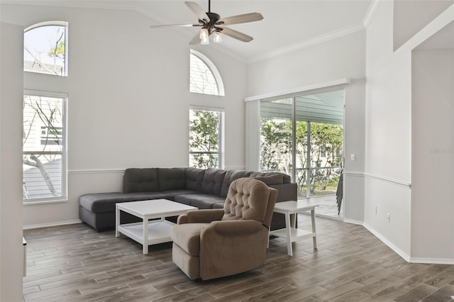 living room with dark hardwood / wood-style flooring, high vaulted ceiling, a wealth of natural light, and ornamental molding