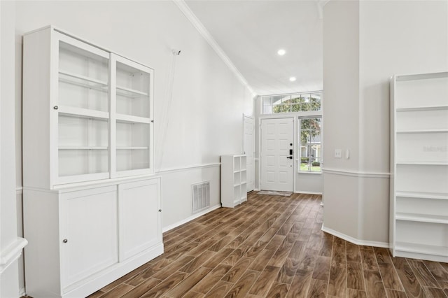 foyer featuring crown molding and dark hardwood / wood-style flooring