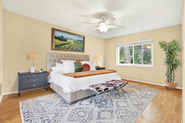 bedroom featuring ceiling fan, a textured ceiling, and light wood-type flooring