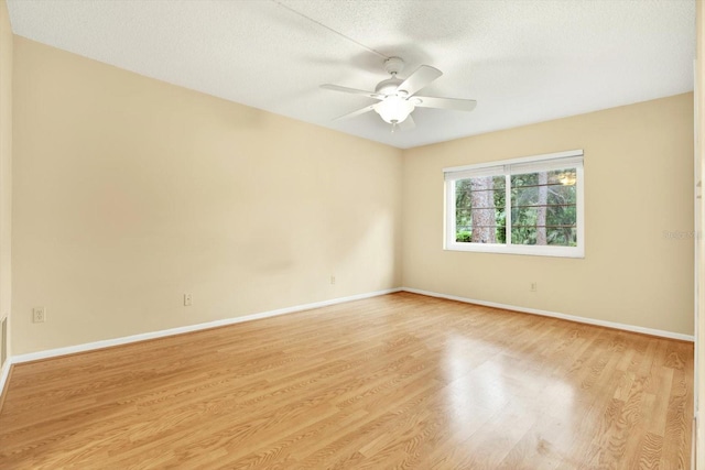 empty room featuring a textured ceiling, ceiling fan, and light wood-type flooring