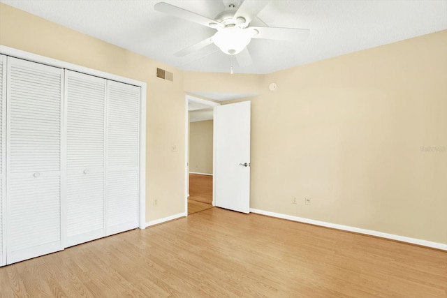 unfurnished bedroom with ceiling fan, a closet, and light wood-type flooring