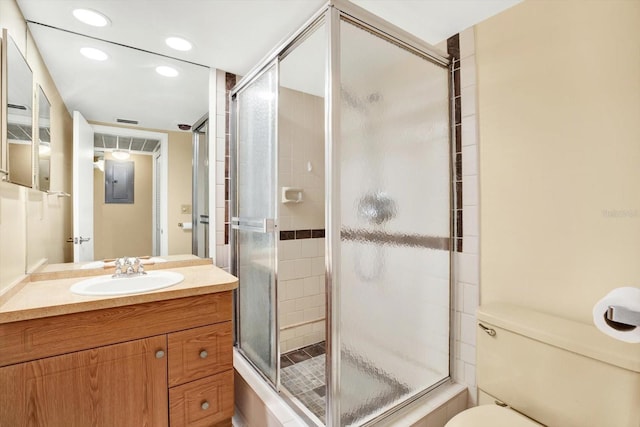 bathroom with walk in shower, vanity, toilet, and electric panel