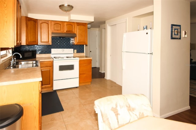 kitchen with white appliances, light tile patterned floors, sink, and backsplash