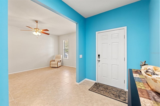 entryway with light tile patterned floors, baseboards, and a ceiling fan