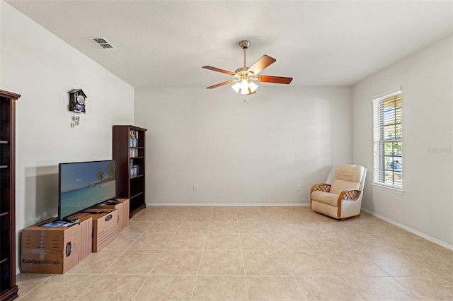 sitting room with light tile patterned floors, baseboards, visible vents, and a ceiling fan