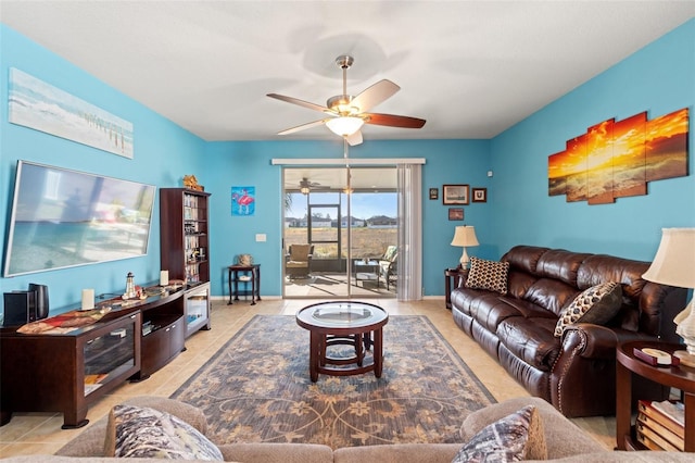 living room featuring light tile patterned floors, ceiling fan, and baseboards