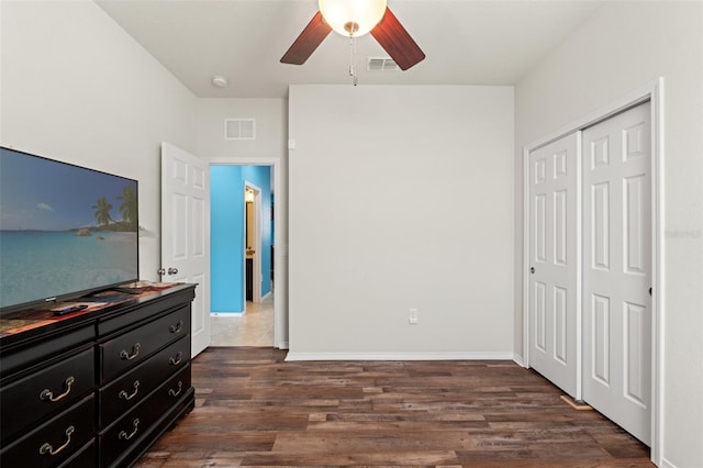 bedroom with baseboards, a closet, visible vents, and dark wood-type flooring