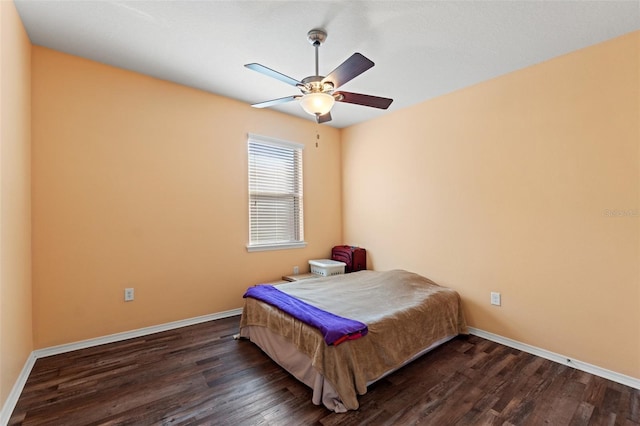 bedroom featuring dark wood-style floors, a ceiling fan, and baseboards