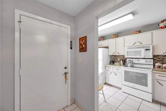 kitchen with light tile patterned flooring, white appliances, a textured ceiling, and backsplash