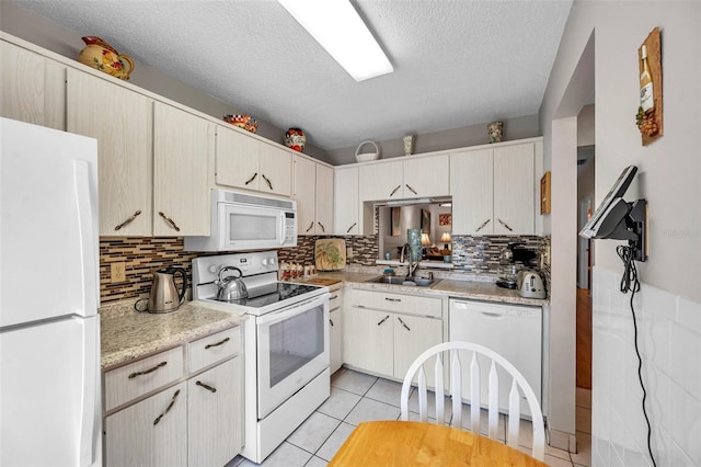 kitchen with light tile patterned flooring, tasteful backsplash, sink, white appliances, and a textured ceiling