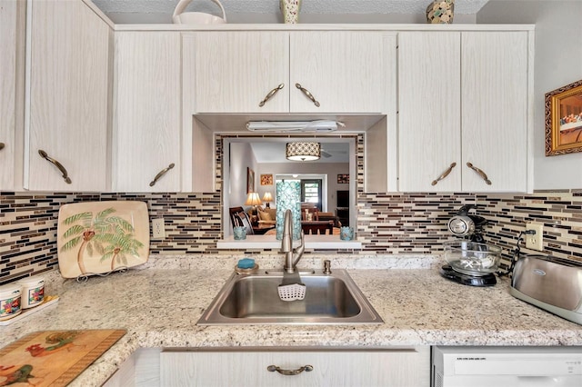 kitchen featuring sink, backsplash, and white dishwasher