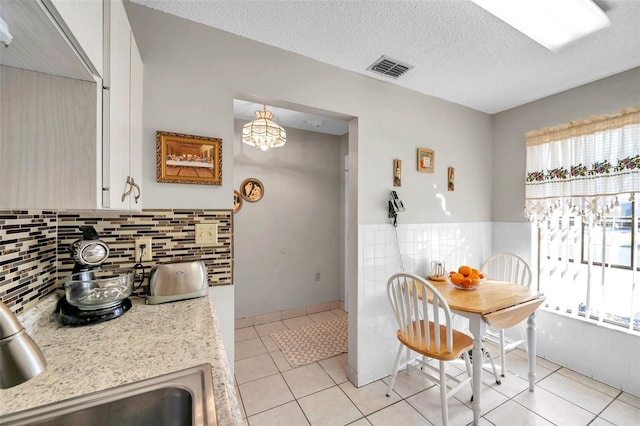 kitchen featuring light tile patterned flooring, plenty of natural light, and a textured ceiling