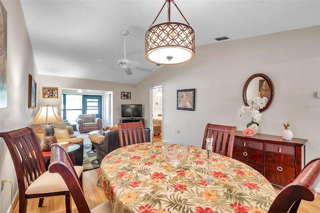 dining space with lofted ceiling, ceiling fan, and light wood-type flooring