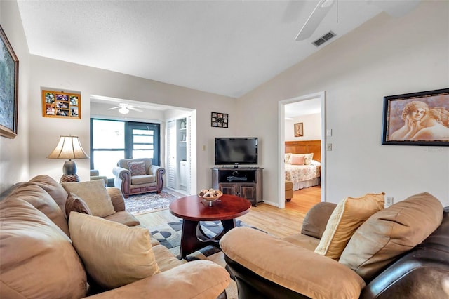 living room featuring lofted ceiling, light hardwood / wood-style floors, and ceiling fan