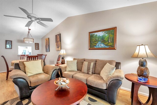 living room featuring ceiling fan, vaulted ceiling, and light wood-type flooring