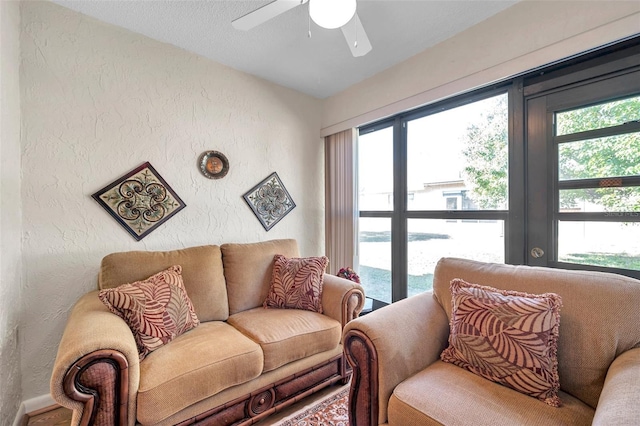 living room featuring ceiling fan and a wealth of natural light