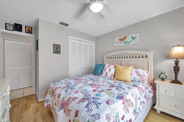 bedroom with ceiling fan, a textured ceiling, light wood-type flooring, and a closet