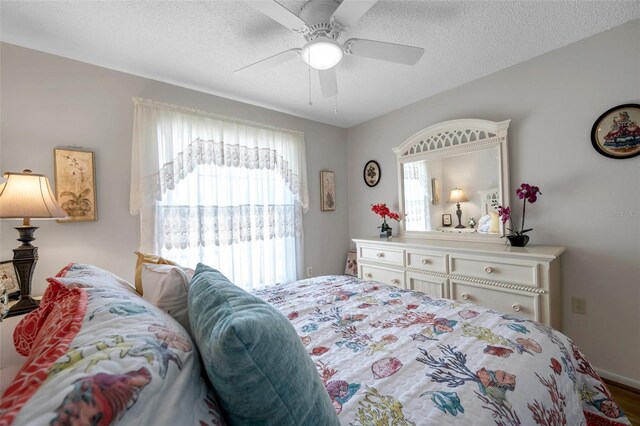 bedroom with ceiling fan and a textured ceiling