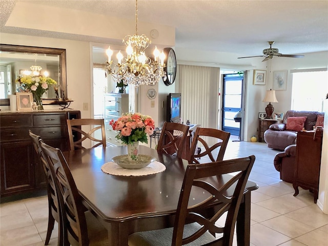dining area with light tile patterned flooring and ceiling fan with notable chandelier
