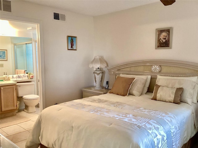 bedroom featuring light tile patterned floors, connected bathroom, and visible vents
