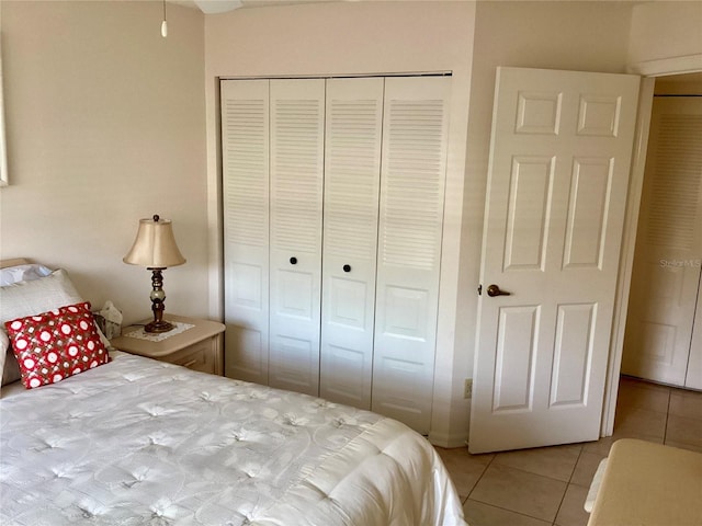 bedroom with light tile patterned floors and a closet
