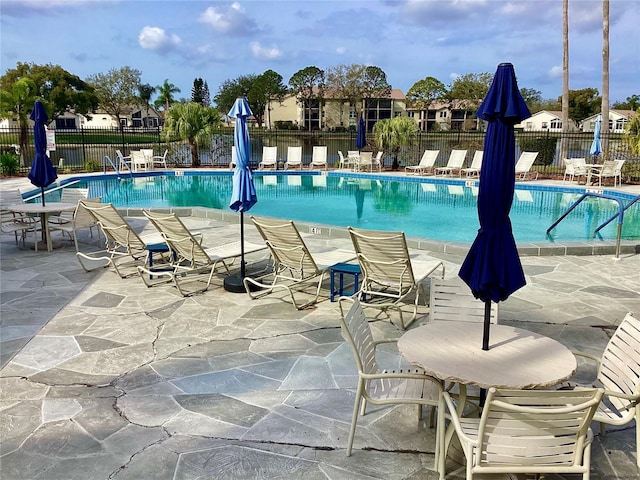 community pool featuring a patio area and fence