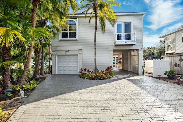 coastal home featuring a balcony and a garage