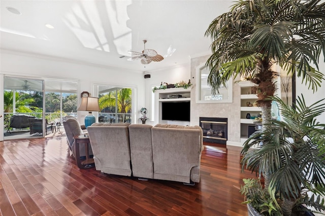 living room featuring dark hardwood / wood-style flooring, ornamental molding, and ceiling fan