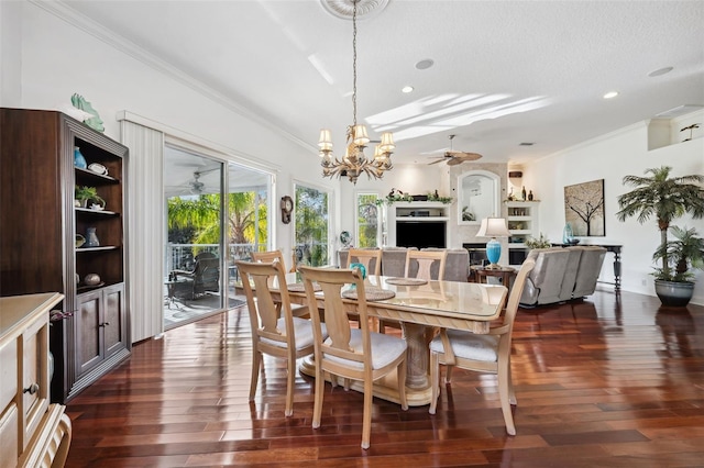 dining room featuring dark wood-type flooring, ornamental molding, and ceiling fan with notable chandelier